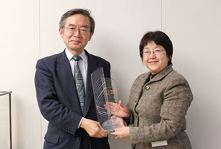 受賞トロフィー授与の様子(当社専務取締役 中嶋 誠(左)とトムソン・ロイター・プロフェッショナル(株) 取締役日本営業統括部長 棚橋 佳子様(右))